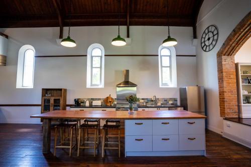 a large kitchen with a large wooden table and chairs at Adelaide Hills Luxury Escape - 1884 Summertown in Summertown