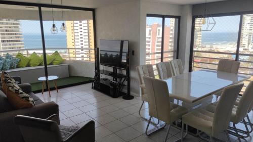 a living room with a table and chairs and a television at DEPTO SUITE II in Iquique