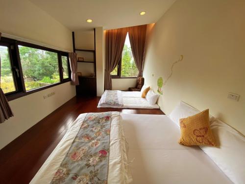 two beds in a room with two windows at SeeU Coffee and B&B in Xihu