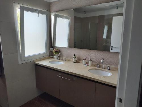 een badkamer met 2 wastafels en een grote spiegel bij Casa Diego in Mendoza