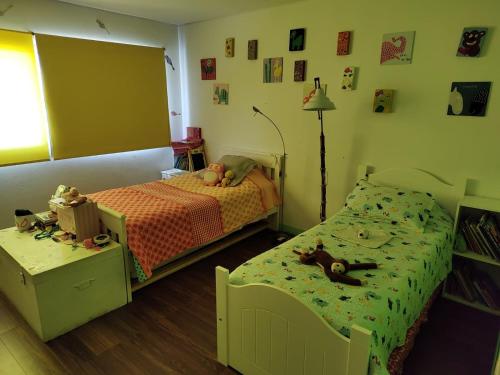 een slaapkamer met 2 bedden met knuffels erop bij Casa Diego in Mendoza