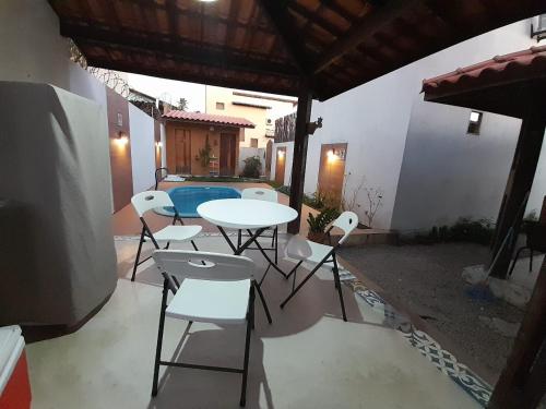 a patio with a table and chairs and a pool at Casa Vila Verde in Pôrto de Pedras