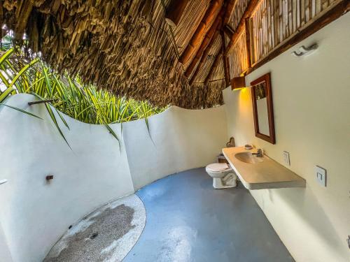 a bathroom with a toilet and a sink at Hotel Playa Bonita Tayrona in Buritaca