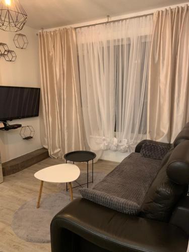 a living room with a couch and a table at Uroczy Apartament z Patio in Szczecin