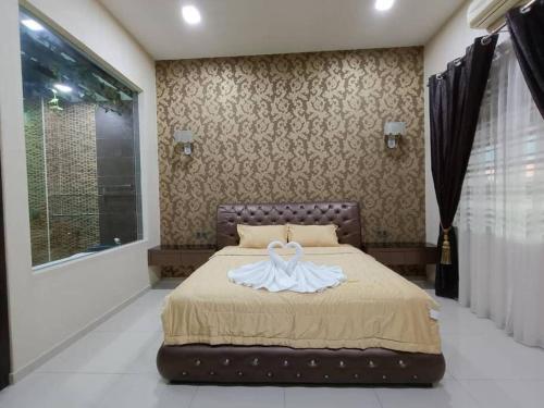 a bedroom with a bed with a swan on it at Oro Homestay in Kluang