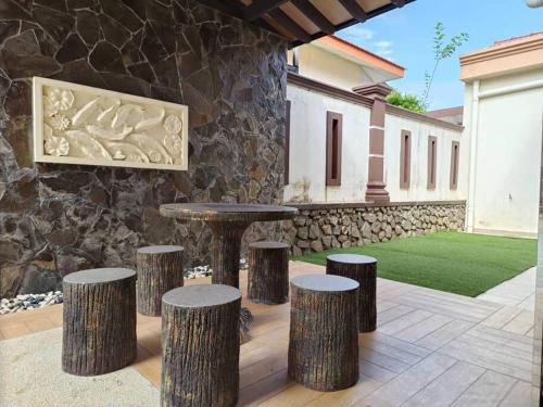une terrasse avec une table et quatre tabourets dans les arbres dans l'établissement Oro Homestay, à Keluang