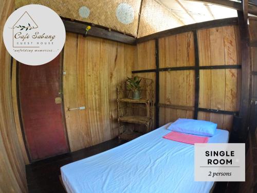 a bedroom with a bed in a wooden room at Cafe Sabang Guest House in Sabang