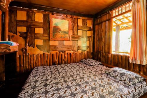 - une chambre avec un lit dans une pièce dotée de murs en bois dans l'établissement Rimbono Homestay, à Borobudur