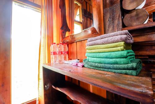 a pile of towels sitting on a wooden shelf at Rimbono Homestay in Borobudur