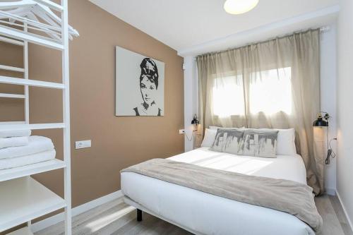 ein Schlafzimmer mit einem weißen Bett und einem Fenster in der Unterkunft Amazing Attic With Terrace in Hospitalet de Llobregat