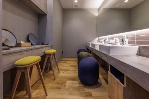 a bathroom with a sink and two stools at Minakami Onsen Aratashi Minakami in Minakami