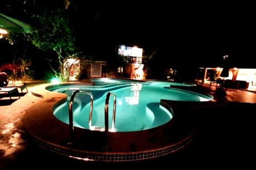 uma grande piscina à noite com luzes em Imbassai - Casa Alto Padrão completa - Condominio Fechado - A2B1 em Imbassaí