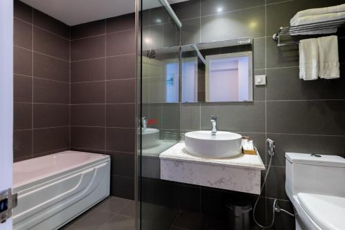 bagno con lavandino, servizi igienici e specchio di Venue Hotel Nha Trang a Nha Trang