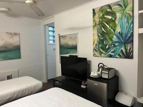 1 dormitorio con 1 cama y TV en una mesa en Bungalow Hotel, en Cairns
