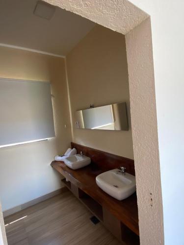a bathroom with two sinks and a mirror at Chalezinho Pousada in Brumadinho