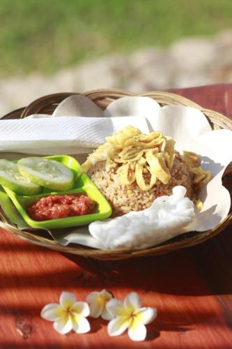 a plate of food with rice and vegetables on a table at Beach Camp Lombok in Sekotong