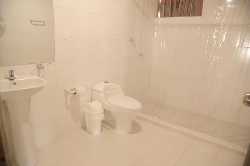 a white bathroom with a toilet and a sink at Club Camping Islamar in Baru