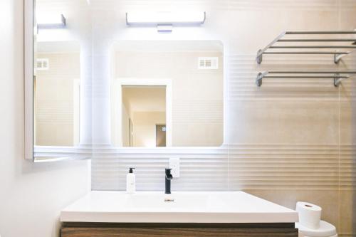 uma casa de banho com um lavatório branco e um espelho. em @ Marbella Lane - Exquisite Home 3BR em Sunnyvale