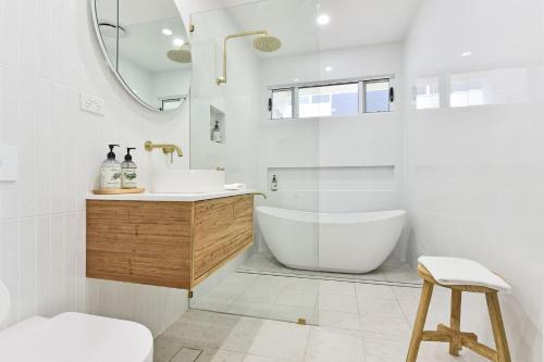 een badkamer met een bad, een wastafel en een spiegel bij Valentine Views Lakefront Tranquility with Private Jetty in Toronto