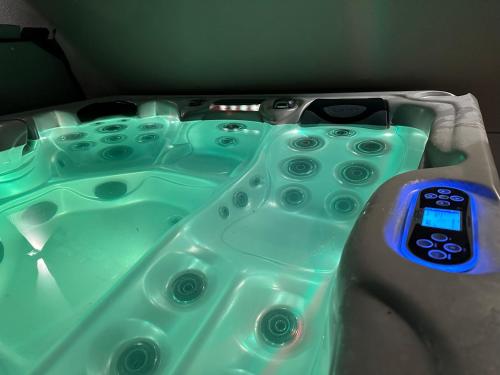 a green bath tub with a remote control in it at L’escale du Roy : maison récente proche versailles in La Queue-lès-Yvelines
