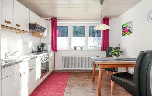 a kitchen with a wooden table and a dining room at Awesome Apartment In Dalaas Wald With Wifi And 1 Bedrooms in Ausserwald