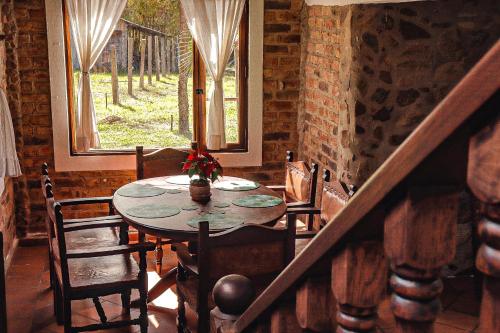 mesa y sillas en una habitación con ventana en Casa de las Palmas en Villa de Leyva