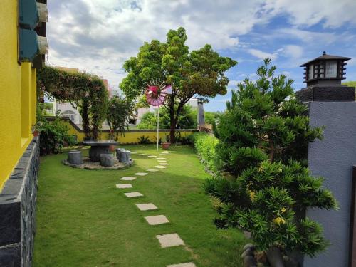 un jardín con un camino de piedra en el césped en Meet Bay B&B, en Xiyu