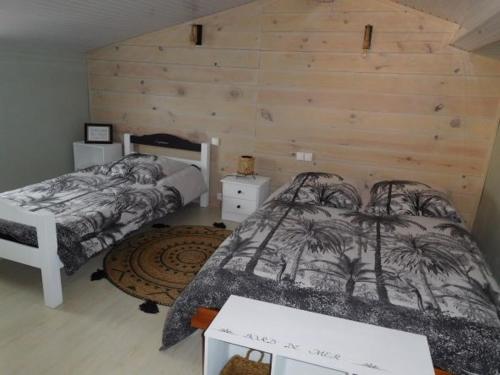 1 Schlafzimmer mit 2 Betten und einer Holzwand in der Unterkunft Maison La Faute-sur-Mer, 4 pièces, 5 personnes - FR-1-476-173 in La Faute-sur-Mer