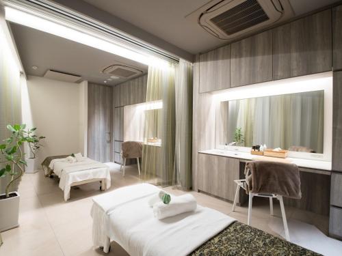 a spa room with two beds and a mirror at Atami Sekaie in Atami