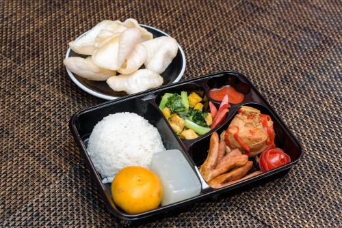 two containers of food with rice and other foods at Yellow Bee Tanah Abang in Jakarta