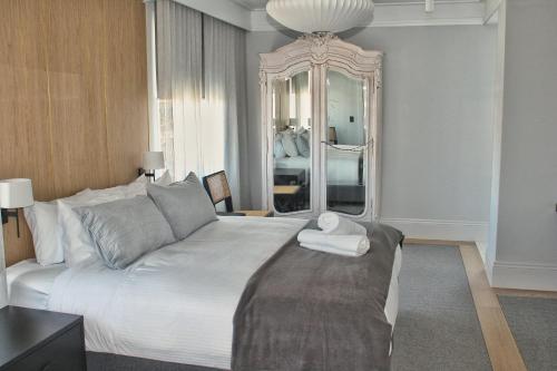 um quarto com uma cama grande e um espelho grande em The Bowral Hotel em Bowral