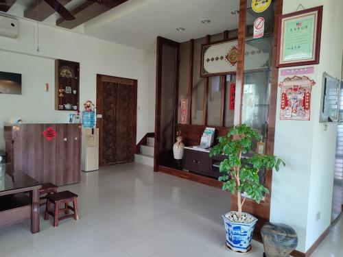 a lobby of a restaurant with a potted plant in the middle at Meet Bay B&B in Xiyu