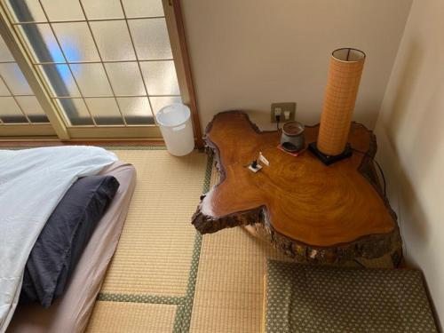 a bedroom with a wooden table next to a bed at HIROSAKI清水森はうす in Hirosaki