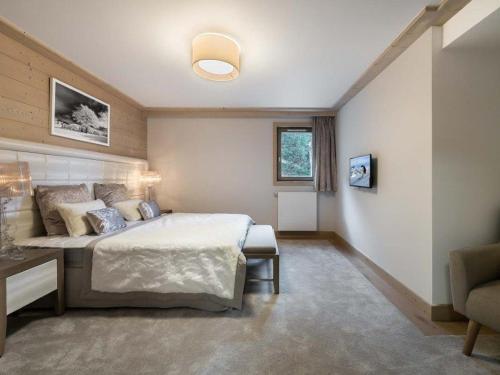a bedroom with a bed and a table and a chair at Appartement Courchevel 1550, 3 pièces, 6 personnes - FR-1-562-64 in Courchevel
