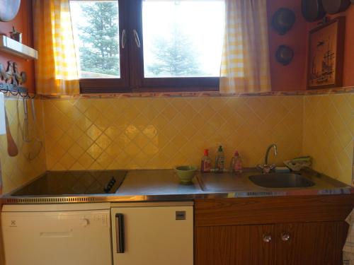 une petite cuisine avec un évier et une fenêtre dans l'établissement Appartement 3 pièces, 6 pers, animaux acceptés, Orcières Merlette - FR-1-636-221, à Orcières