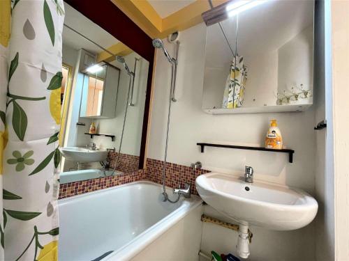 ein Badezimmer mit einem Waschbecken, einer Badewanne und einem Spiegel in der Unterkunft Appartement La Salle-les-Alpes, 2 pièces, 5 personnes - FR-1-330F-212 in La Salle Les Alpes