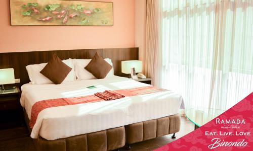 a bedroom with a large bed in a room at Ramada by Wyndham Manila Central in Manila