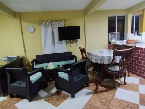 sala de estar con sillas, mesa y TV en POSADA NATIVA PALILLO´S PLACE, en Franshua