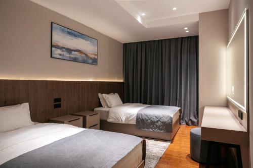 um quarto de hotel com duas camas e uma janela em Raavah Aparthotel em Almaty