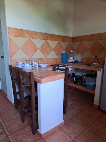 a kitchen with a table and chairs and a counter at Manglar Pacific in Los Ayala