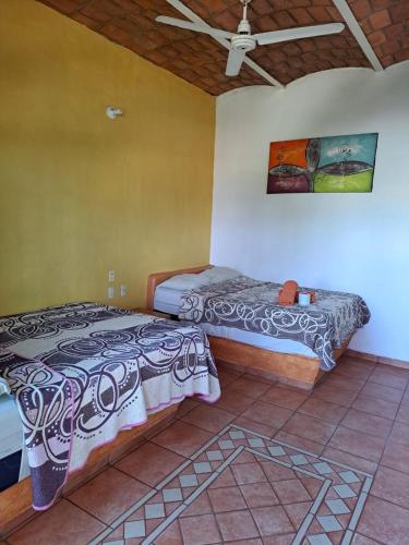 a bedroom with two beds and a ceiling at Manglar Pacific in Los Ayala