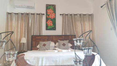 a bedroom with a bed and a table with two candles at Kai Selfcatering Apartment in La Digue