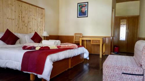 a bedroom with two beds and a desk and a chair at Chamba resort in Leh