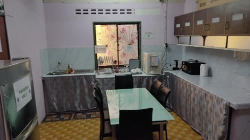 a kitchen with a table and chairs and a counter at JSW Inn in Gelugor