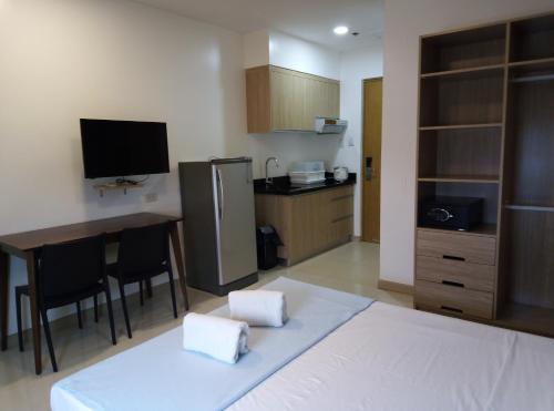 - une cuisine avec un lit, une table et un réfrigérateur dans l'établissement CHATSWOOD RESIDENCES, à Mandaue City