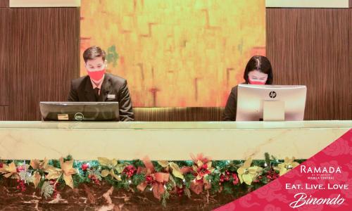 two people sitting at a desk with their laptops at Ramada by Wyndham Manila Central in Manila