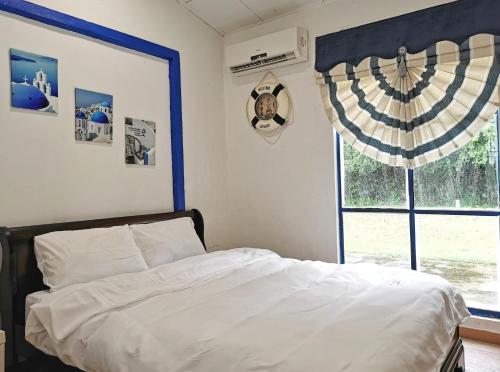 Schlafzimmer mit einem Bett und einem Fenster in der Unterkunft Yussy Homestay at Afamosa Villa in Kampong Alor Gajah