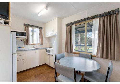 a kitchen with a table and a table and chairs at Discovery Parks - Coffin Bay in Coffin Bay