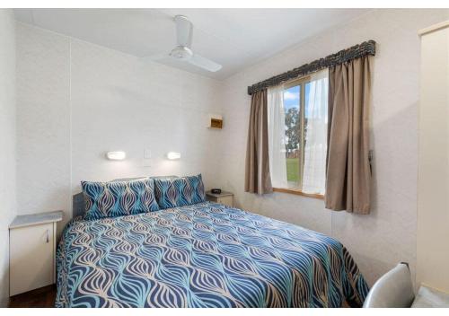 a bedroom with a bed and a window at Discovery Parks - Coffin Bay in Coffin Bay