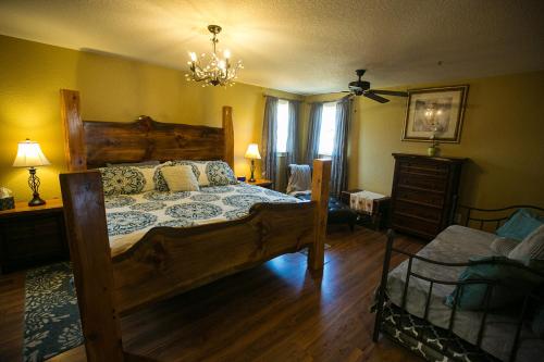 a bedroom with a large wooden bed and a chandelier at Climb On Inn - Red River Gorge Kentucky - Amazing Home ! 